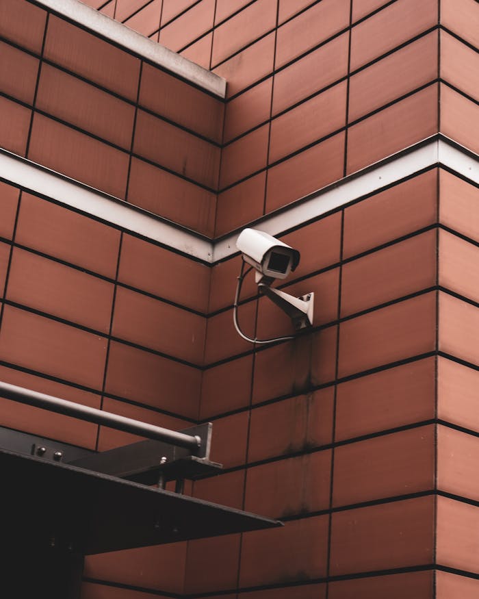 About Security camera monitoring a red brick building exterior, symbolizing modern surveillance in Germany.